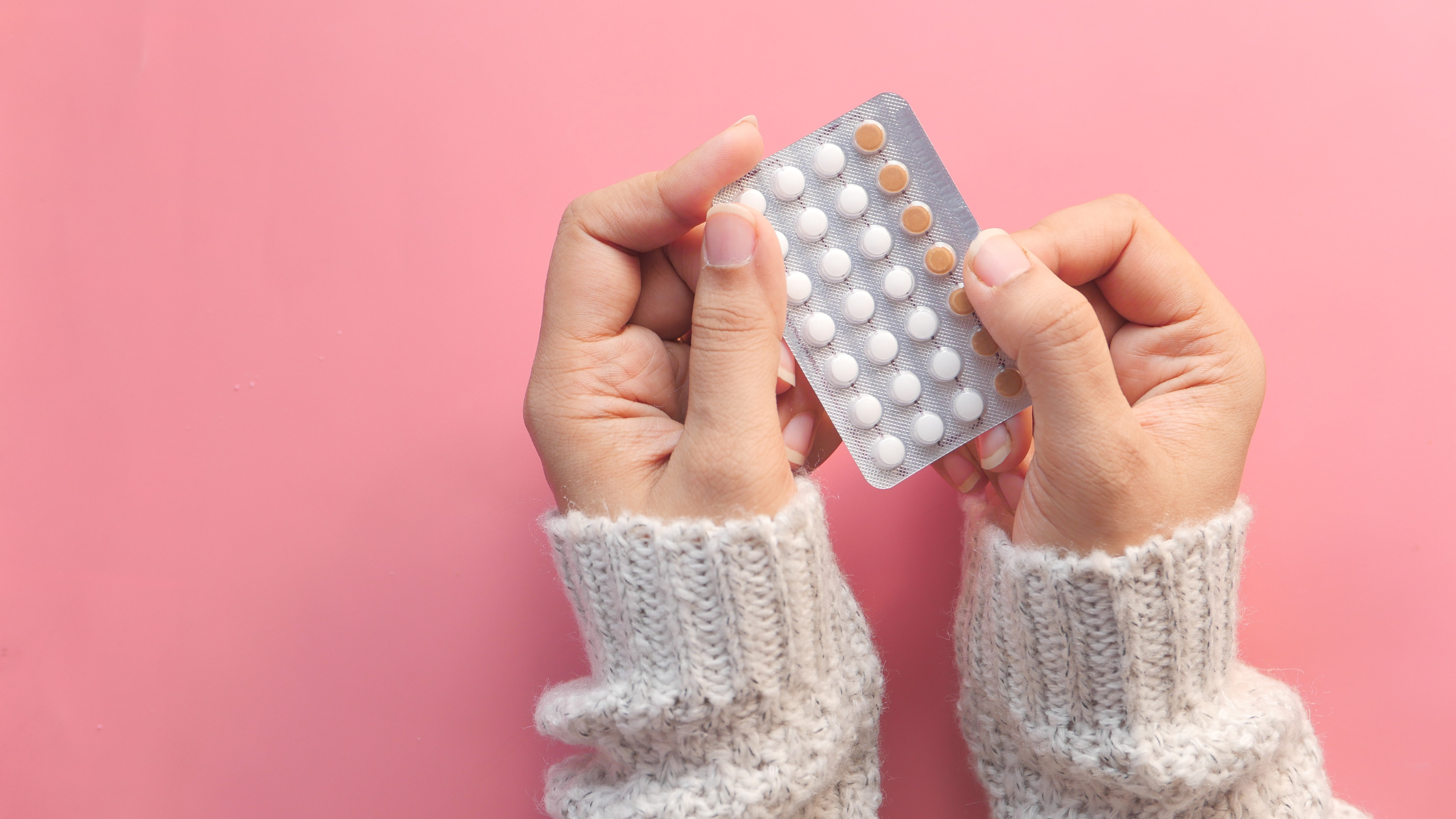 girl's hands holding birth control pills
