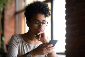 Woman With Glasses Searching on Smartphone